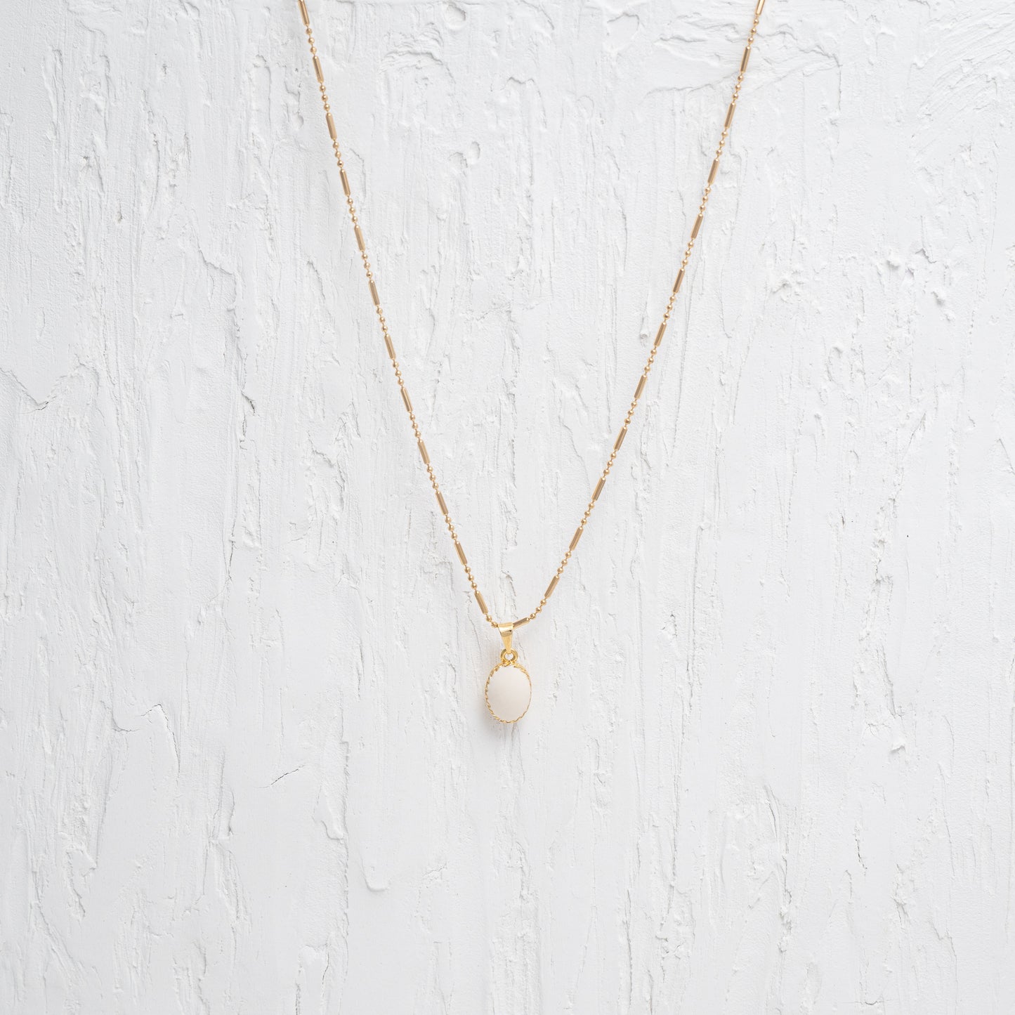 Elegant white oval charm necklace on a delicate chain, showcasing a lustrous pendant for a touch of sophistication.