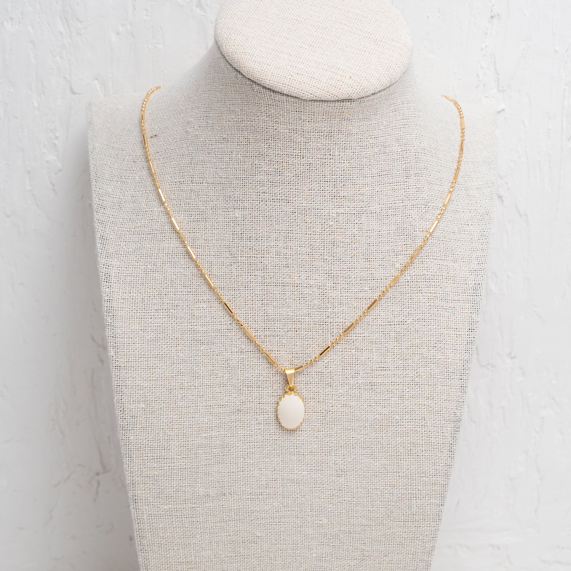 Minimalist necklace featuring a radiant white oval charm, perfect for adding a subtle, chic accent to any outfit.