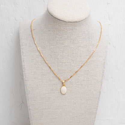 Minimalist necklace featuring a radiant white oval charm, perfect for adding a subtle, chic accent to any outfit.