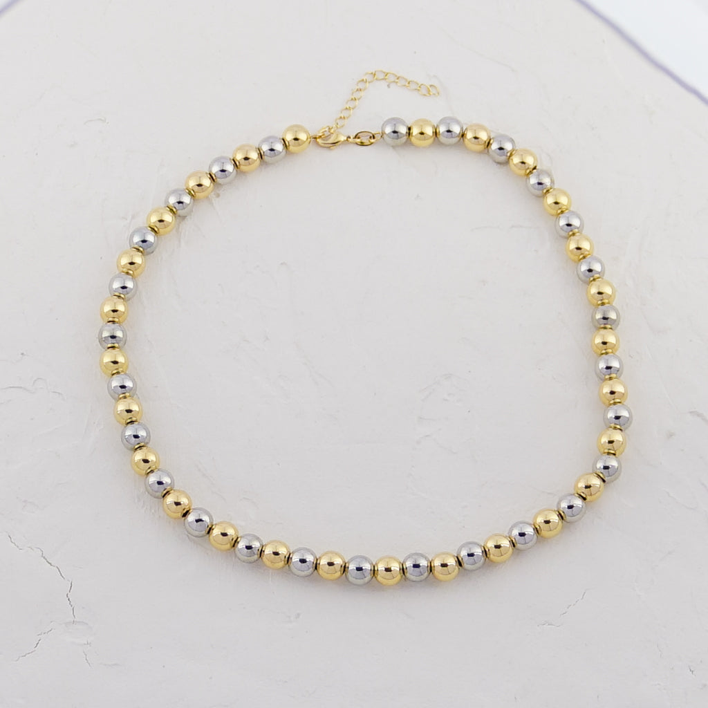 Elegant Two-Tone Beaded Necklace laid against a white background, highlighting the contrast between gold and silver beads.