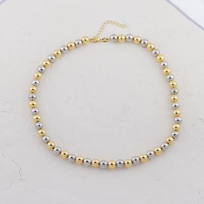 Elegant Two-Tone Beaded Necklace laid against a white background, highlighting the contrast between gold and silver beads.