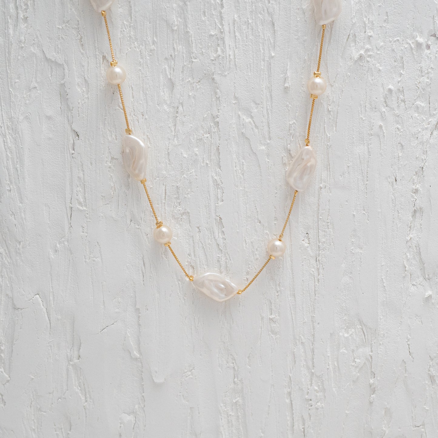 Versatile Gold Chain Necklace with a Captivating Flat Baroque Pearl, embodying elegance and uniqueness.