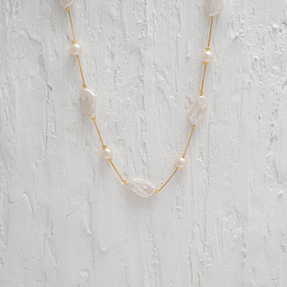 Versatile Gold Chain Necklace with a Captivating Flat Baroque Pearl, embodying elegance and uniqueness.