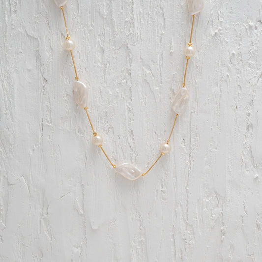 Versatile Gold Chain Necklace with a Captivating Flat Baroque Pearl, embodying elegance and uniqueness.