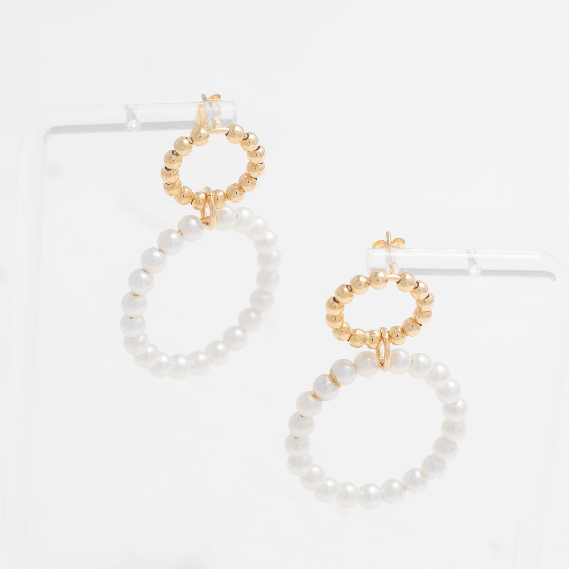  Pearl Earrings set in a polished gold circular frame for a timeless accessory