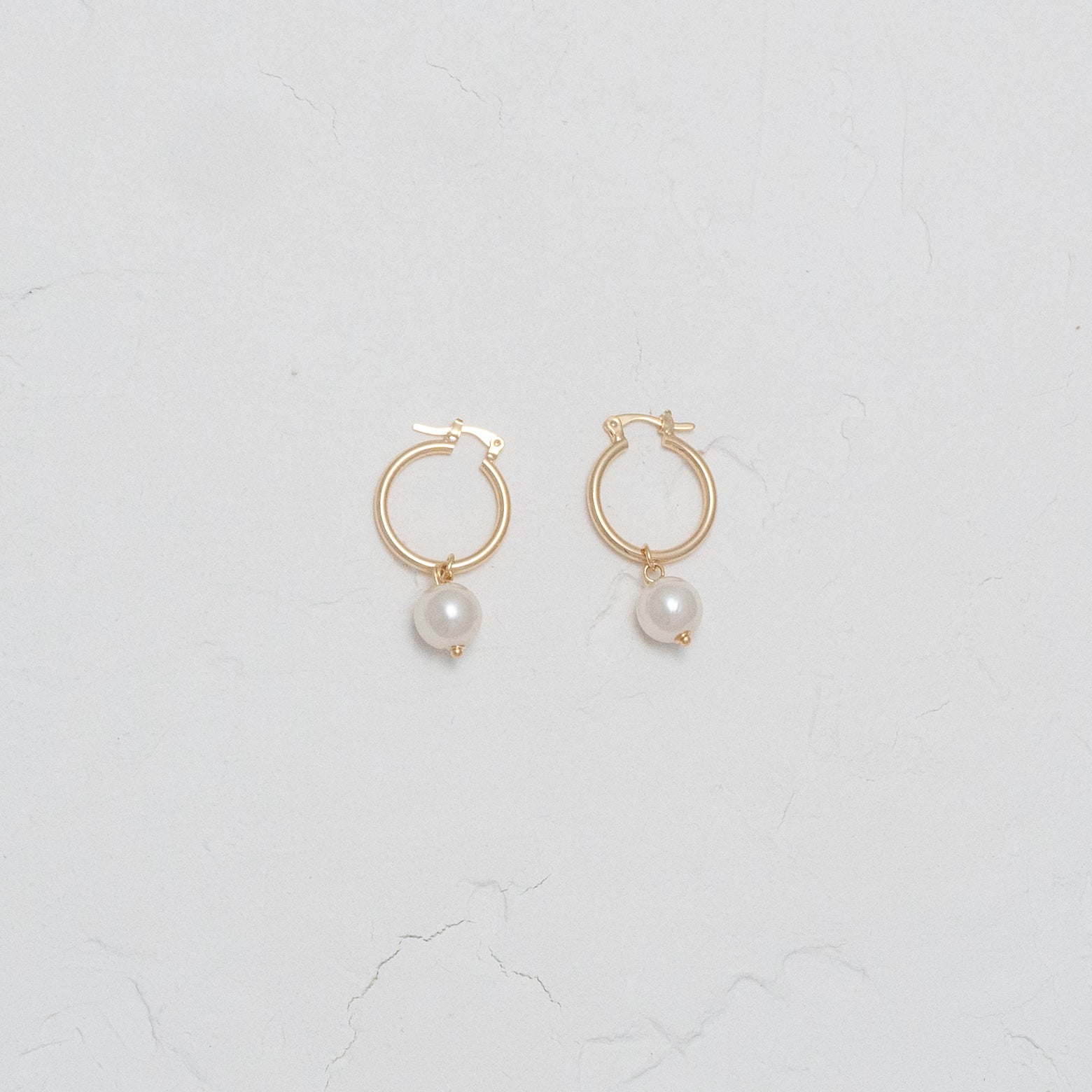 Elegant Pearl and Gold Dangle Hoops, showcasing timeless elegance with a modern twist.