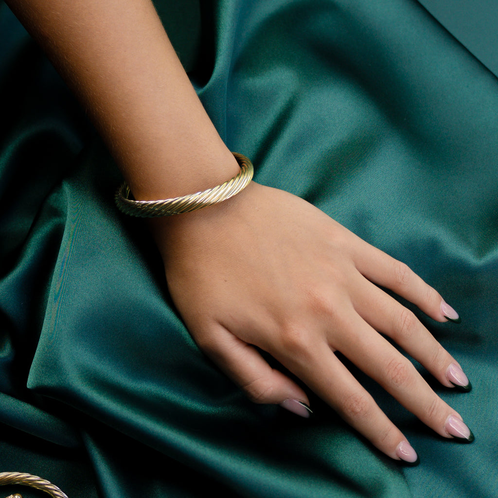 Model wearing Twisted Gold Bangle displayed at a slight angle