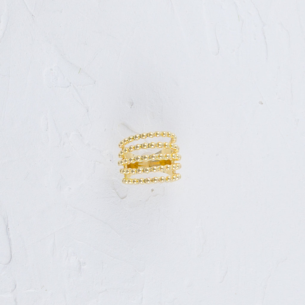 Multiple Beaded Strand Gold Ring placed flat on a white surface.