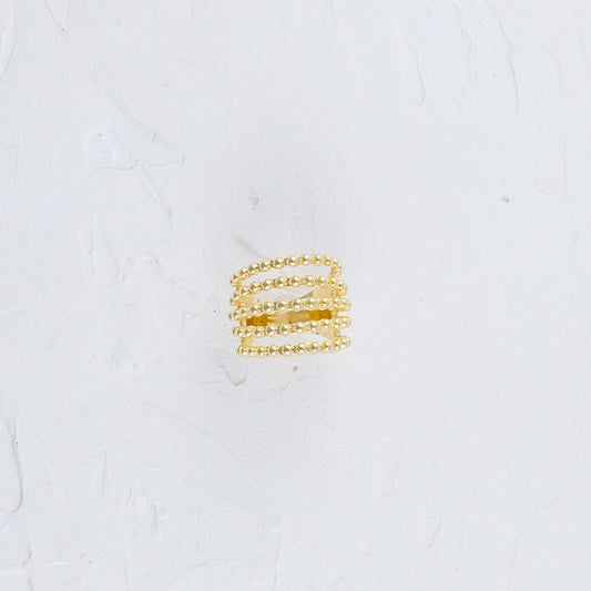 Multiple Beaded Strand Gold Ring placed flat on a white surface.